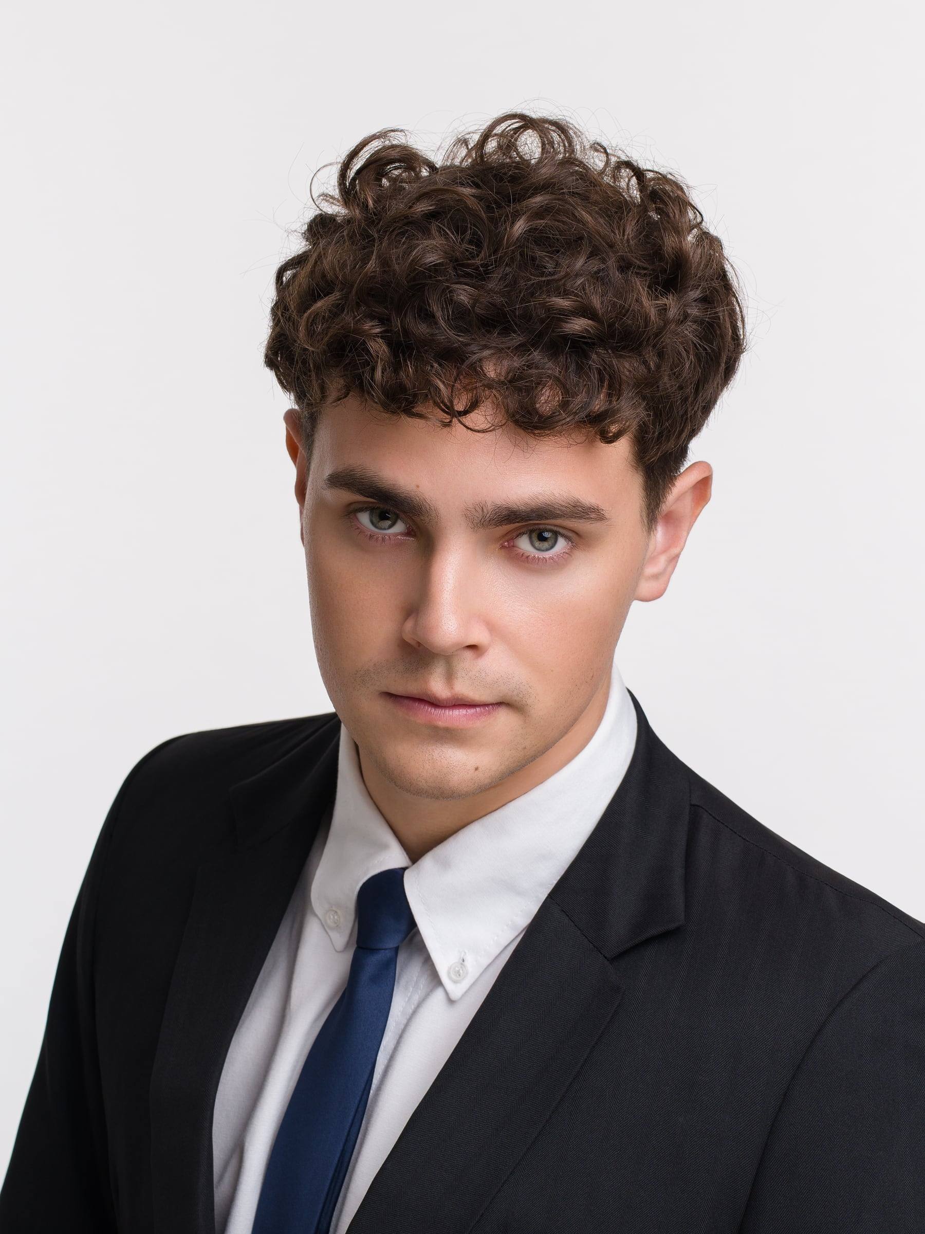 Jorge Tyrakowski in a black suit, white shirt and navy tie, headshot