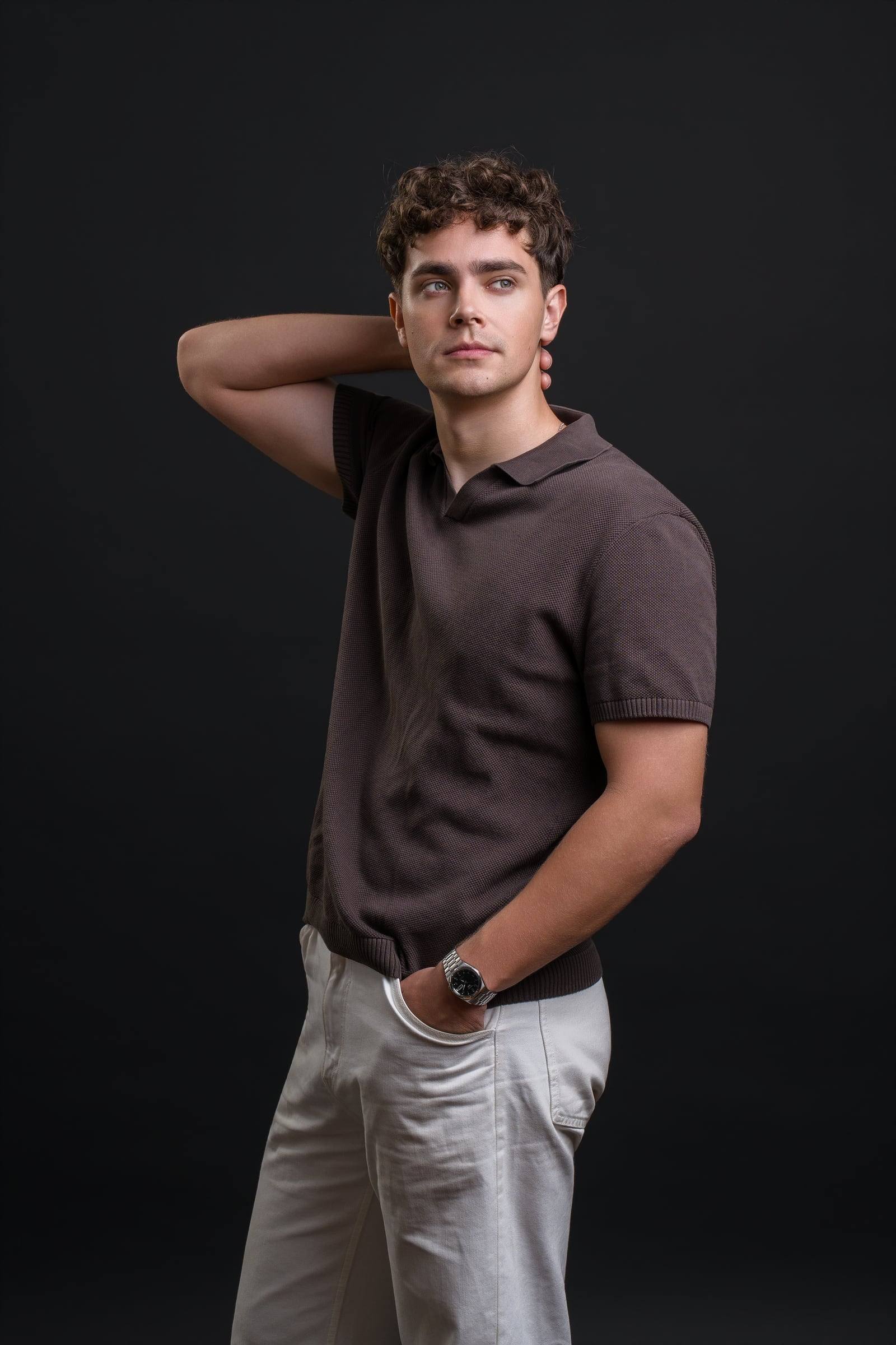 Jorge Tyrakowski in a brown knit polo and light trousers, hand behind his head