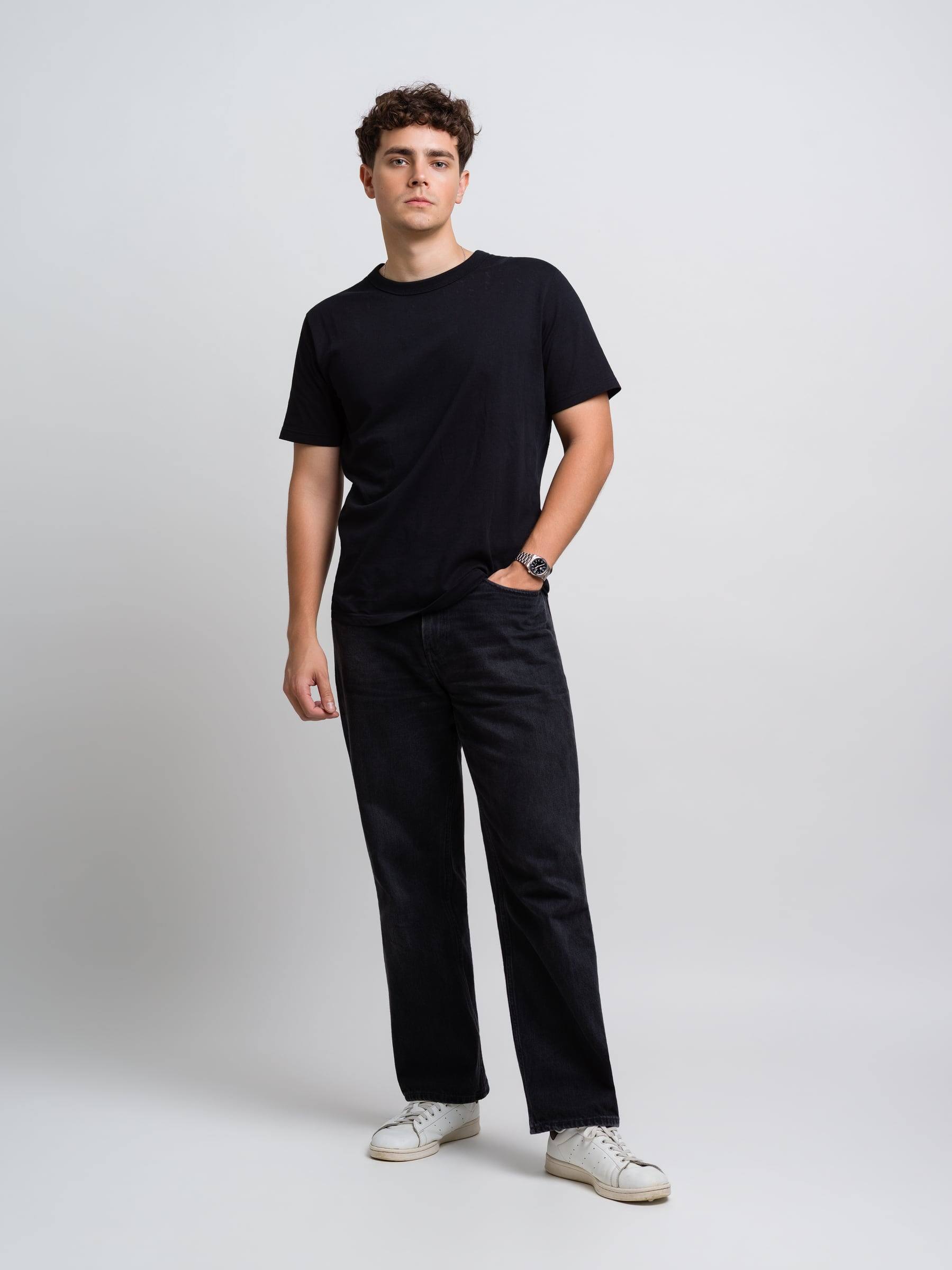 Jorge Tyrakowski in a black T-shirt and black jeans, full length